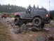 1989 Ford Bronco - A modified 1989 Ford Bronco navigates a rocky trail, with another SUV visible in the background.