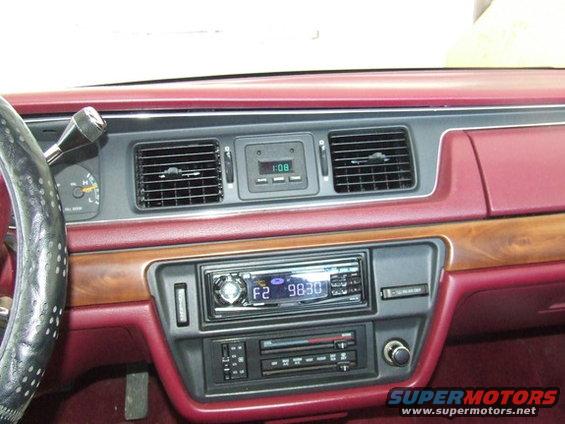 Dashboard of a 1992 Ford Crown Victoria, showing the radio, climate controls, and digital clock