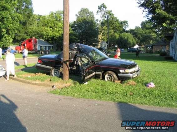 1999 Ford Crown Victoria crashed into a utility pole, driver's door open, roof crushed