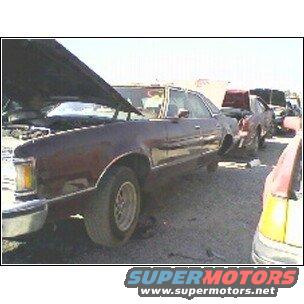 Dark red Ford Ranchero in a junkyard, hood up. Other cars visible in background
