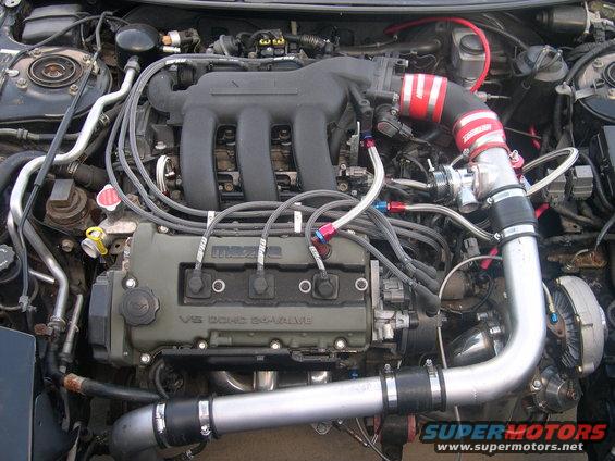 Engine bay with V6 DOHC 24-valve engine, modified intake, and turbocharger components. Visible "MAZDA" branding on valve cover