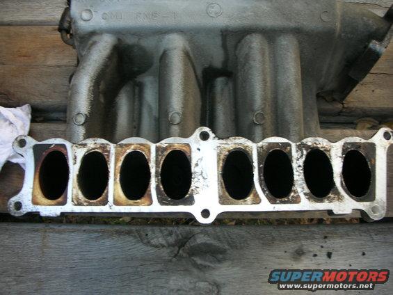 Intake manifold with eight ports on a wooden surface