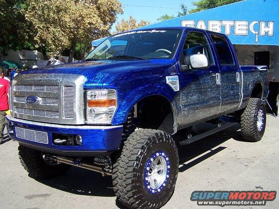 Blue Ford F-Series truck with custom paint and large off-road tires