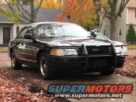Black 2000 Ford Crown Victoria Police Interceptor with a push bar, parked outside