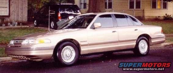 1993 Ford Crown Victoria parked on street with a black SUV behind it