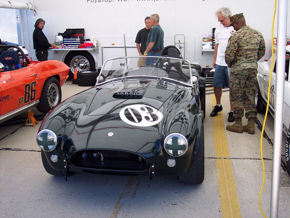 Dark green convertible race car with white number 03 on hood, front view