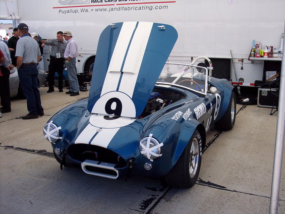 Blue and white race car with hood open, number 9 on hood