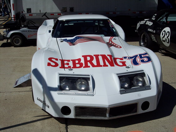 White race car with SEBRING 75 livery and American flag graphic on hood