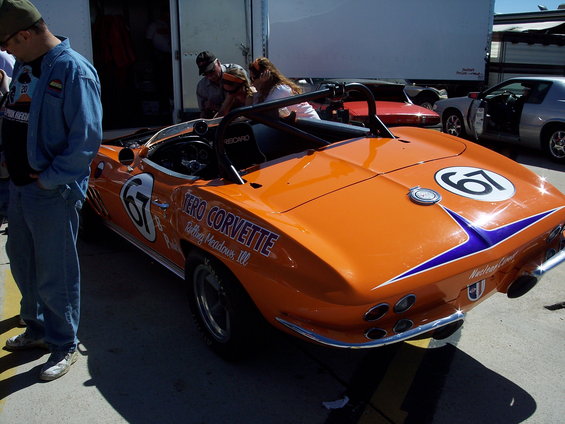 Orange 1967 Corvette race car with number 67 on rear and side, blue stripe detail