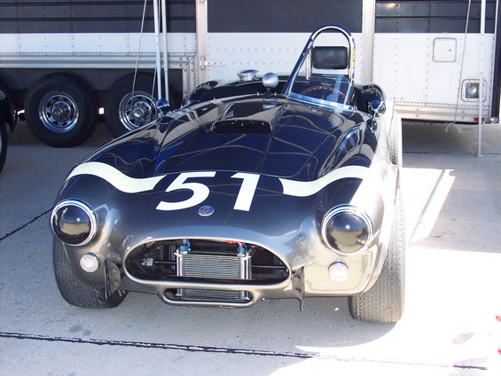 Dark blue racing car with white stripes and number 51, front view, showing exposed radiator