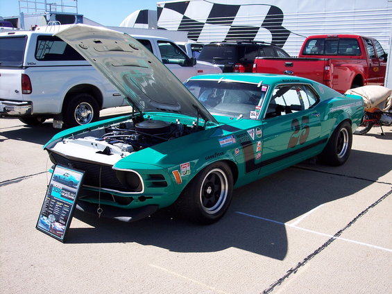 Teal 1970s racing car with hood open, number 66 on door