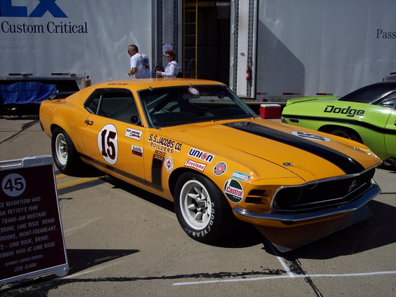 Yellow 1969 Ford Mustang race car with black stripes and number 15 on door