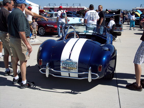Blue convertible with dual white racing stripes and chrome bumpers. License plate reads CSX4800 COBRA