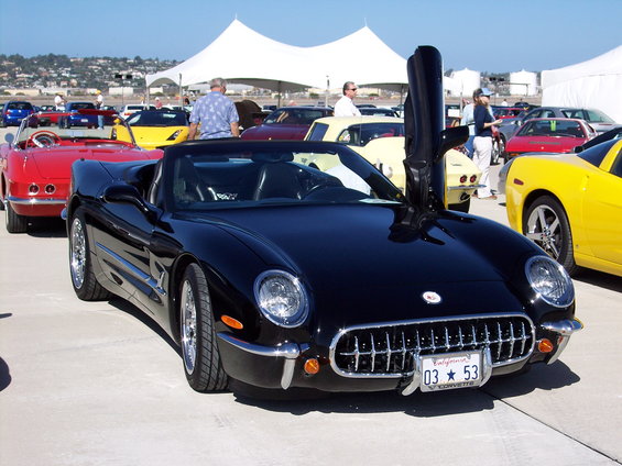 Black convertible sports car with butterfly doors, chrome grille, and California license plate