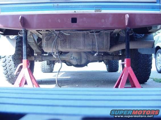 1985 Ford Bronco rear axle and fuel tank on jack stands, showing suspension and exhaust