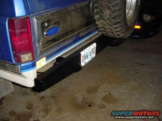 Rear of blue Ford Bronco with spare tire mounted, showing new black bumper and license plate UKW 650