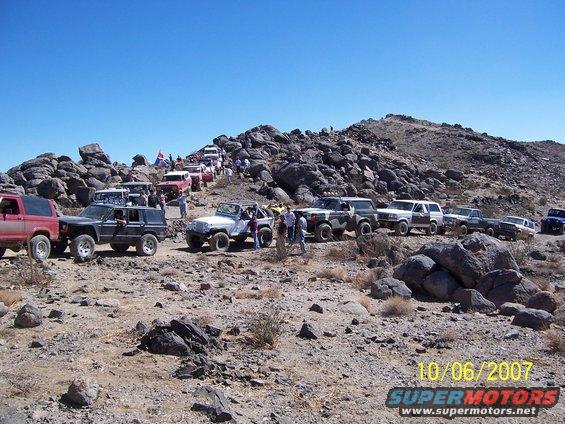 Multiple off-road vehicles parked on a rocky incline under a clear blue sky. Date stamp reads 10/06/2007