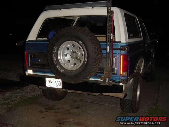 Rear view of blue Ford Bronco with spare tire mounted on back. License plate reads UKW 650