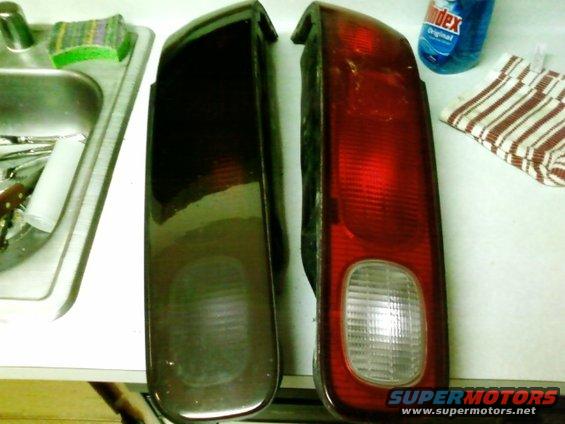 Two tail lights, one red and one dark, on a counter next to a sink