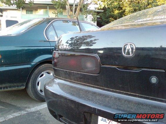 Black Acura Integra rear, left taillight visible, Acura logo on trunk