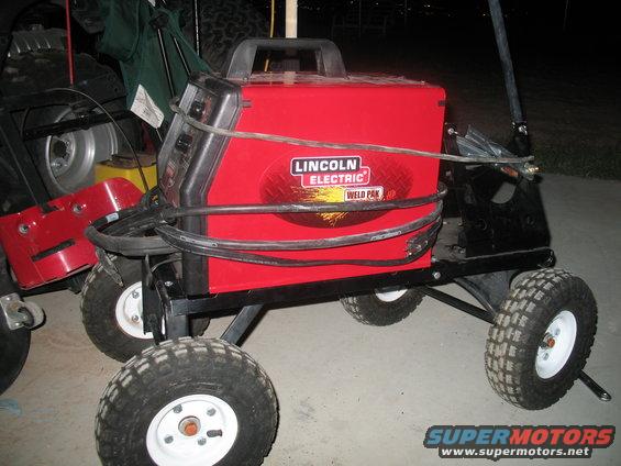 Red Lincoln Electric Weld Pak welding machine on a four-wheeled cart