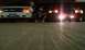 1998 Ford Crown Victoria - A person poses between two vehicles in a dimly lit area.