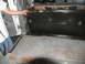 1995 Ford C-350 (Centurion Conversions) - The interior of a van is shown with a panel being held up, revealing the floor and dashboard area.