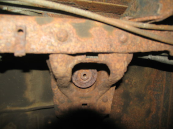 Rusted chassis component with visible bolt head