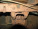 1995 Ford C-350 (Centurion Conversions) - Close-up view of a heavily rusted chassis component, likely part of the suspension or frame.