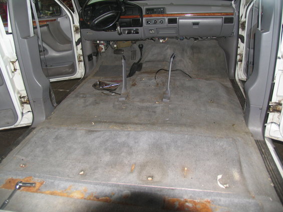 Interior of a van with carpet removed, showing the floor and dashboard