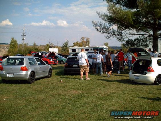 Silver Volkswagen Golf with black rims, rear view, parked on grass