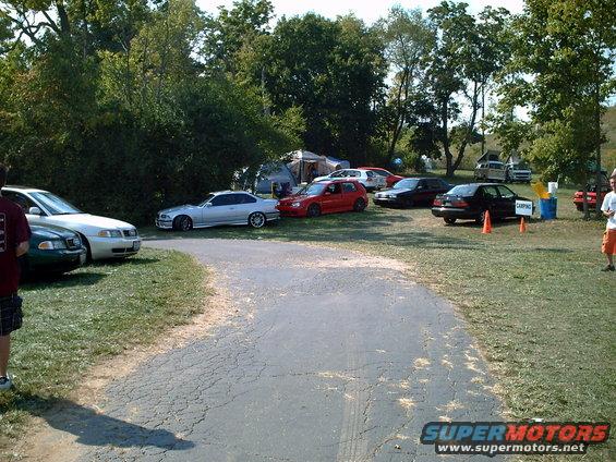Silver coupe parked on grass, side view