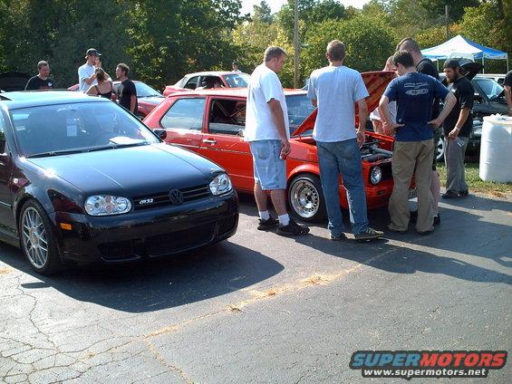 Black Volkswagen Golf GTI with "GTI" badge on the grille, parked on asphalt
