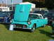 1988 Ford Sport - A classic turquoise and white convertible is displayed with its hood up, parked on a grassy field.