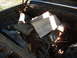 1963 Ford Galaxie - The engine bay of a car is shown, with parts obscured by wooden planks.