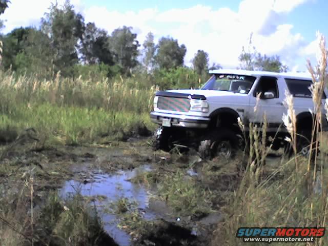 White 1995 Ford Bronco stuck in mud during off-roading