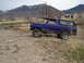 1978 Ford Bronco - This 1978 Ford Bronco is captured in a three-quarter front view as it navigates a dirt path with a mountainous backdrop.
