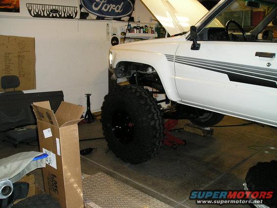White 1986 Toyota Hilux with large off-road tires, hood up