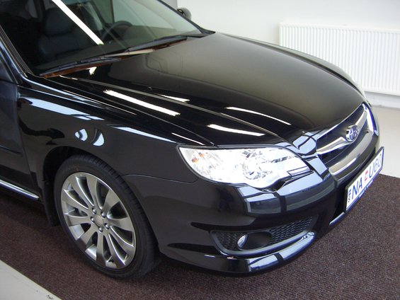 Black car's front quarter view, showing headlight and grille