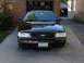 2003 Ford Crown Victoria - A black 2003 Ford Crown Victoria is parked in front of a garage.