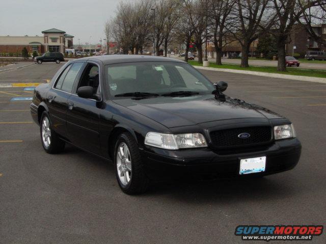 Black Ford Crown Victoria parked in a lot, front quarter view