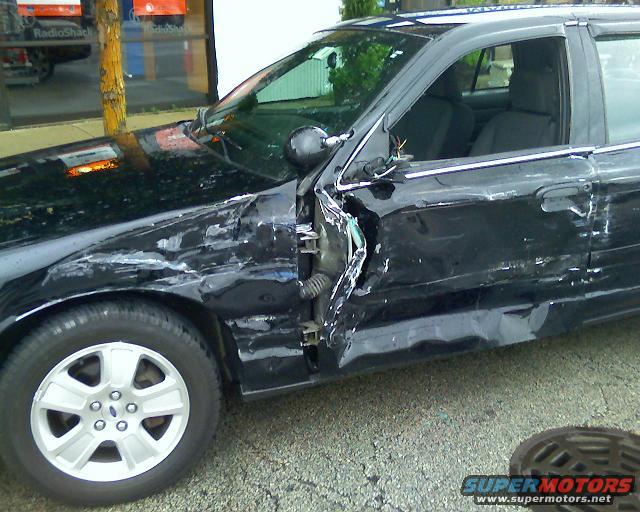 2003 Ford Crown Victoria with severe damage to the driver's side front fender and door
