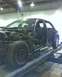 2003 Ford Crown Victoria - A damaged car is shown on a lift in a repair shop, with its engine and interior exposed.