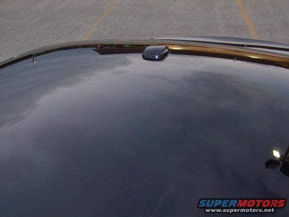 Dark car roof with a black antenna pod near the front