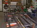 1964 Ford Ranchero - A disassembled vehicle chassis and rear axle assembly is shown in a workshop setting.