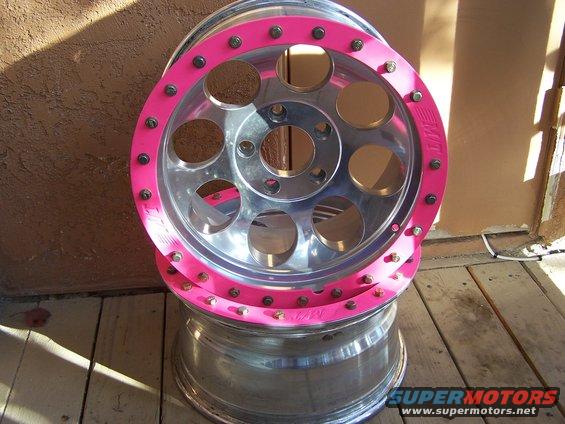 Chrome wheel with pink trim and visible lug nuts