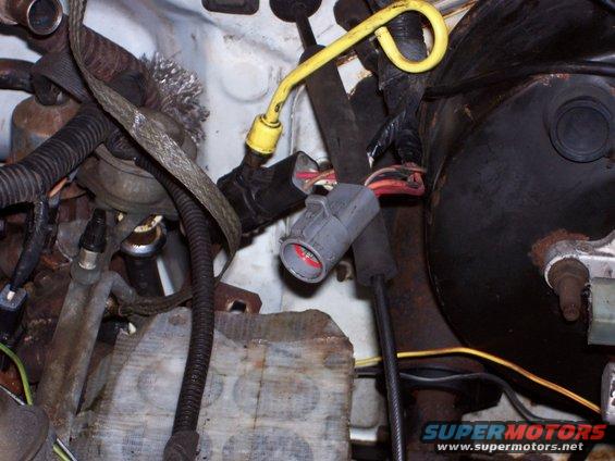 Close-up of engine bay wiring and brake booster with connectors