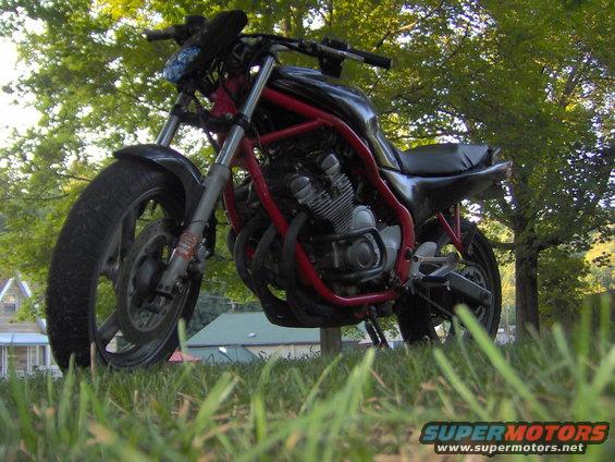 Motorcycle with red frame and black tank parked outdoors
