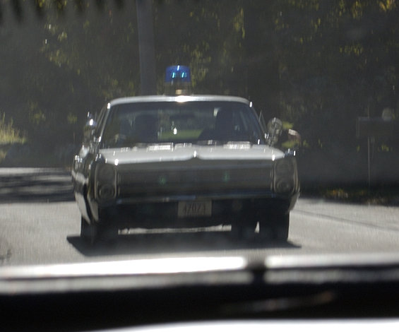 Front view of a 1973 police car with a blue light on the roof and license plate 47071