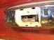 1978 Ford Bronco - Close-up of a vehicle's interior dome light assembly, showing its internal components and chrome trim.